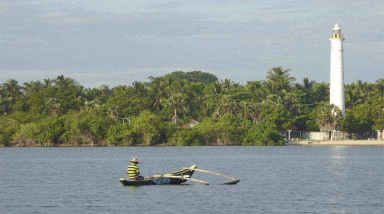faro y laguna con pescador que ver y que hacer en Batticaloa