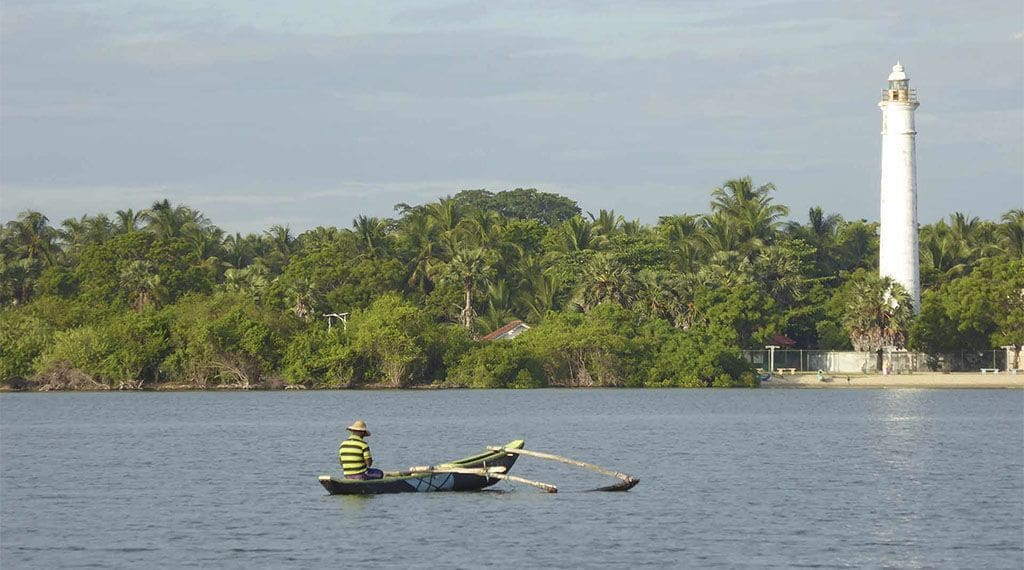 faro y laguna con pescador que ver y que hacer en Batticaloa
