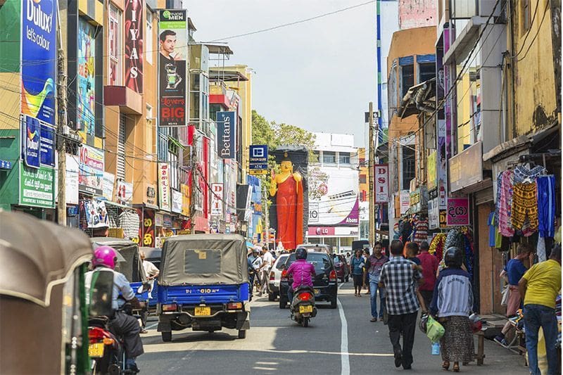 Main Street en Galle, gente y la estatua de Buda