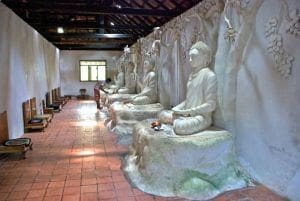 estatuas de Buda y visitante dentro del templo Panchakapaduwa en Bentota