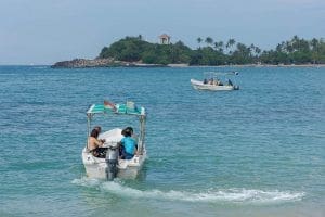 personas en un bote en el oceano yendo a bucear en la playa de Unawatuna