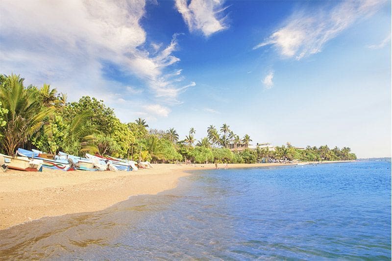 playa de Ventura Beach en Bentota con barcos y un oceano y cielo azules en un dia soleado