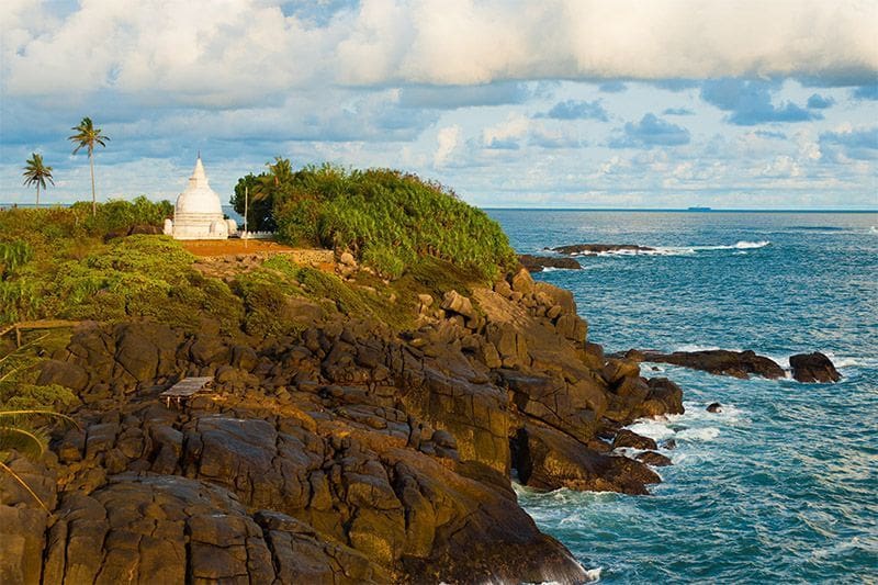 que hacer en Unawatua vista de las rocas mirando al oceano, la estupa y el cielo