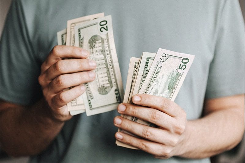 una persona contando billetes de dolar estadounidense