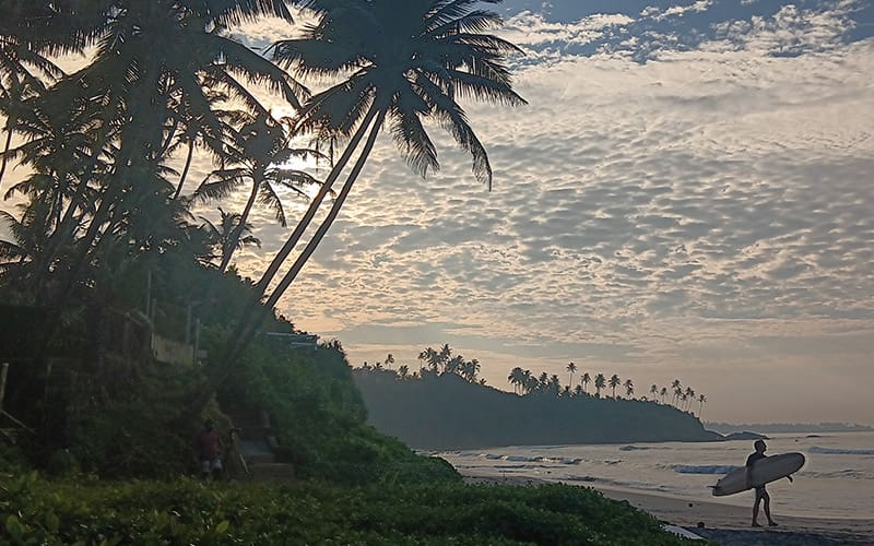 SK Town Beach en Matara al amanecer y surfero