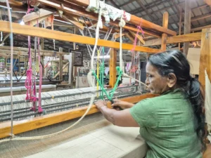 empleada local trabajando maquina hilar taller artesanal Sooriya Weaving Mills Sri Lanka