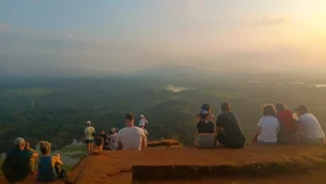 atardecer y turistas en la cima de la roca del leon